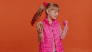 Toddler children girl hold dumbbell and sweet donut cake choosing between fitness diet or junk food video