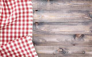 Red checkered tablecloth on light wooden table with, top view with copy space photo