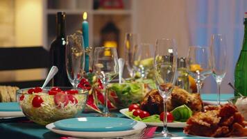 tradicional comida para Navidad celebracion de amigos. velas en el mesa. Navidad celebracion en decorado habitación lleno de globo decoraciones y Navidad árbol con chimenea, grande festivo cena comida para grande familia video