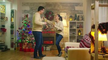 romántico joven Pareja bailando en Navidad día y Bebiendo champán. Navidad fiesta juntos celebracion de amar, divertido danza romántico estilo de vida en decorado habitación con hogar en antecedentes video