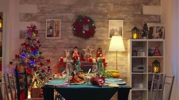 table magnifique décoré pour Noël fête. Noël arbre et Zoom dans tir. Noël fête dans décoré pièce plein de globe décorations et Noël arbre avec cheminée, gros de fête dîner repas pour grand famille video