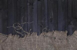 Dark wooden table background with burlap, top view photo