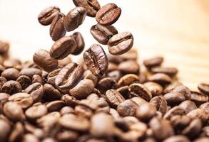 Flying coffee beans. Coffee beans falling on pile isolated on white background photo