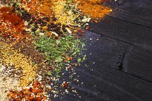 Herbs and spices over black wooden background. Top view with copy space photo