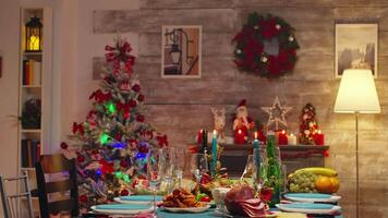 Gourmet food for christmas celebration on the table. Candles on the table. Xmas celebration in decorated room full of globe decorations and christmas tree with fireplace, big festive dinner meal for large family video