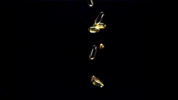 Capsules of vitamin omega 3 fall on the table. On a black background. Filmed on a high-speed camera at 1000 fps. video