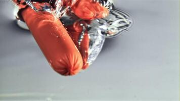 Sausages fall into clean water with air bubbles. Macro background. Filmed on a high-speed camera at 1000 fps.High quality FullHD footage video