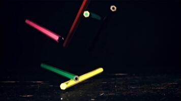 Colored pencils fall on the table. On a black background. Filmed is slow motion 1000 fps. High quality FullHD footage video
