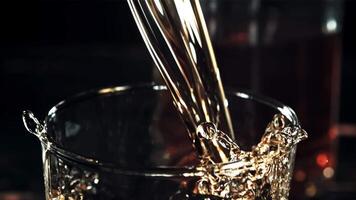 Cognac con spruzzi è versato in un' bicchiere. su un' nero sfondo.filmato su un' alta velocità telecamera a 1000 fps. alto qualità FullHD metraggio video