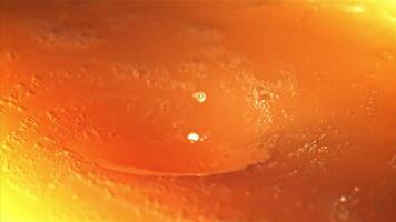 A whirlpool of orange juice with air bubbles. Macro background.Filmed on a high-speed camera at 1000 fps. High quality FullHD footage video