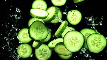 Pieces of fresh cucumbers fly up with drops of water. On a black background.Filmed on a high-speed camera at 1000 fps. video