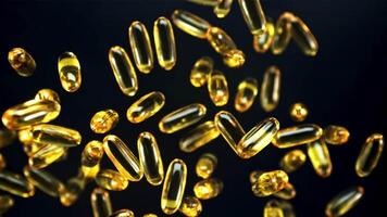 Omega 3 vitamin capsules rotate slowly in flight. On a black background. Filmed is slow motion 1000 fps. video