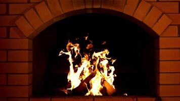 uma brilhante chama do fogo queimaduras dentro a forno. contra uma Sombrio fundo. filmado é lento movimento 1000 fps. video