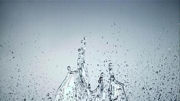 Splashes of water soar up and fall. On a blue background. Filmed is slow motion 1000 fps. video