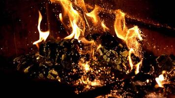 Burning wood is broken with a fire pit with sparks of flame. On a black background. Filmed is slow motion 1000 fps. video