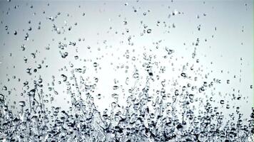 Splashes of water soar up and fall. On a blue background. Filmed is slow motion 1000 fps. video