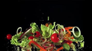 Sliced lettuce, onions, peppers and tomatoes soar up and fall. On a black background. Filmed on a high-speed camera at 1000 fps. video