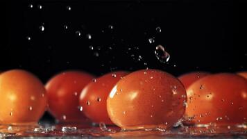 water valt Aan de ei roterend Aan de tafel. Aan een zwart achtergrond. gefilmd is langzaam beweging 1000 fps. video