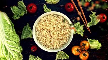 Spices fall on the noodles in the bowl. Top view. On a black background. Filmed on a high-speed camera at 1000 fps. video