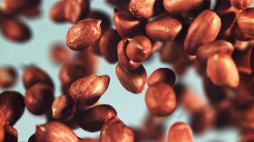 Peanuts fly up and rotate in flight. On a blue background. Filmed is slow motion 1000 fps. video