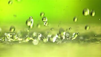 Water droplets fall with splashes. On a green background.Filmed is slow motion 1000 fps. video