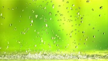 Water droplets fall with splashes. On a green background.Filmed is slow motion 1000 fps. video