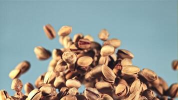 pistachos en vuelo. en un azul antecedentes. filmado es lento movimiento 1000 fps. video