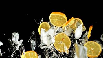 Pieces of lemon and ice fly up and fall down. On a black background. Filmed on a high-speed camera at 1000 fps. video