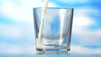 latte è versato in il bicchiere nel un' idromassaggio. su un' blu sfondo.filmato è lento movimento 1000 fps. video