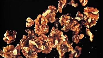 Peeled walnuts take off and rotate in flight. On a black background.Filmed is slow motion 1000 fps. video