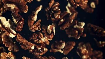 Peeled walnut rises up and falls down. Top view. On a black background. Filmed is slow motion 1000 fps. video