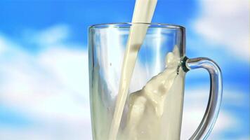 A stream of milk pours into the mug. Against the blue sky. Filmed is slow motion 1000 fps. video