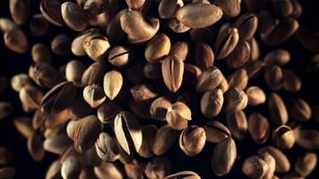 Pistachios rise up and fall down. Top view. On a black background. Filmed is slow motion 1000 fps. video