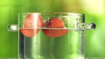 Eggs with splashes fall into a pot of water. On a green background. Filmed on a high-speed camera at 1000 fps. video