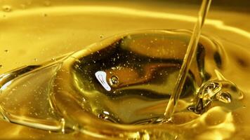 A jet of olive oil flows with waves and splashes. Macro background. Filmed on a high-speed camera at 1000 fps. video