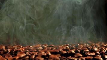 From the roasted coffee beans rises hot steam. On a black background. Filmed on a high-speed camera at 1000 fps. video