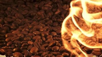 Coffee beans are roasted with tongues of bright flame. Macro background. Filmed is slow motion 1000 fps. video