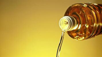 A stream of olive oil pours out of the bottle. On a yellow background. Filmed on a high-speed camera at 1000 fps. video