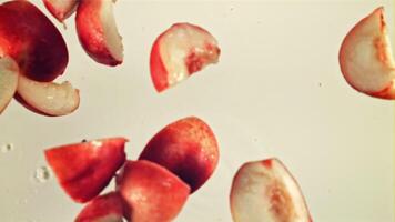 Pieces of fresh peach fall into the milk with splashes. Macro background. Top view. Filmed on a high-speed camera at 1000 fps. video