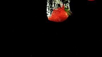 Strawberries fall underwater with bubbles. Filmed is slow motion 1000 fps. High quality FullHD footage video