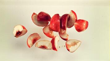 Sliced fresh peach with splashes falls into the milk. Top view. On a white background. Filmed on a high-speed camera at 1000 fps. video