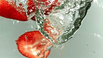 jordgubbar falla in i en bubbelpool. filmad är långsam rörelse 1000 fps. hög kvalitet full HD antal fot video