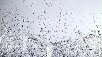 water met spatten stijgt omhoog en valt. Aan een blauw achtergrond. gefilmd is langzaam beweging 1000 fps. video