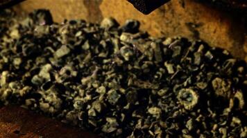 A scoop of burnt coals falls in a furnace of dust. On a black background. Filmed on a high-speed camera at 1000 fps. video