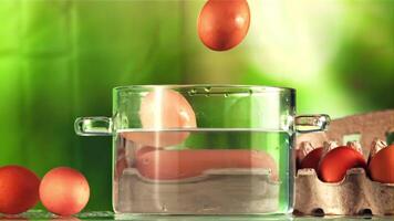 Eggs with splashes fall into a pot of water. On a green background. Filmed on a high-speed camera at 1000 fps. video