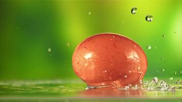 Water drips onto the rotating egg. On a green background. Filmed on a high-speed camera at 1000 fps. video