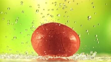 Drops of water fall on the egg. On a green background. Filmed is slow motion 1000 fps. video