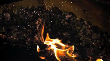 The coals are stirred in the oven with a fireball with flames. On a black background. Filmed on a high-speed camera at 1000 fps. video