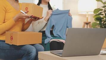 Envío de compras en línea, joven emprendedor de pequeña empresa escribiendo la dirección en una caja de cartón en el lugar de trabajo. video