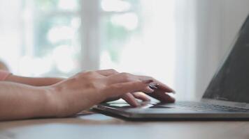 Closeup image of a business woman's hands working and typing on laptop keyboard on glass table video